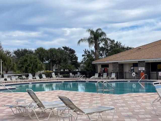 community pool featuring a patio area and fence