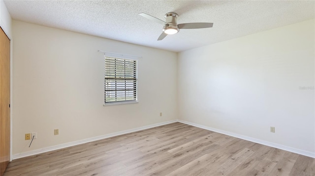 unfurnished room featuring baseboards, ceiling fan, light wood-style flooring, and a textured ceiling