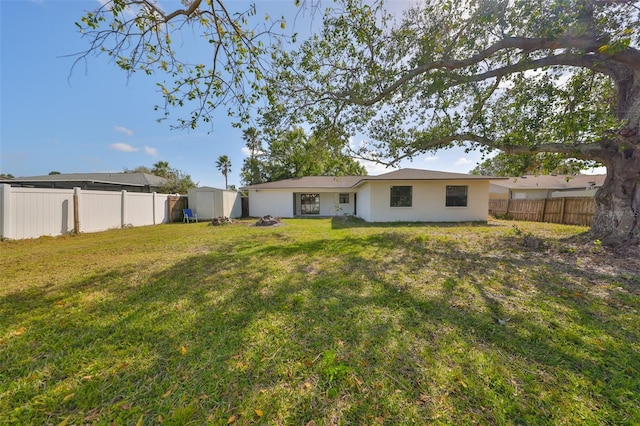 back of property with a shed, a fenced backyard, a lawn, and an outdoor structure