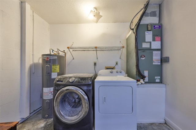 clothes washing area featuring concrete block wall, washing machine and clothes dryer, heating unit, water heater, and laundry area