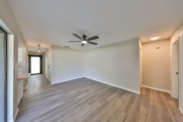 unfurnished room featuring baseboards, visible vents, and light wood finished floors