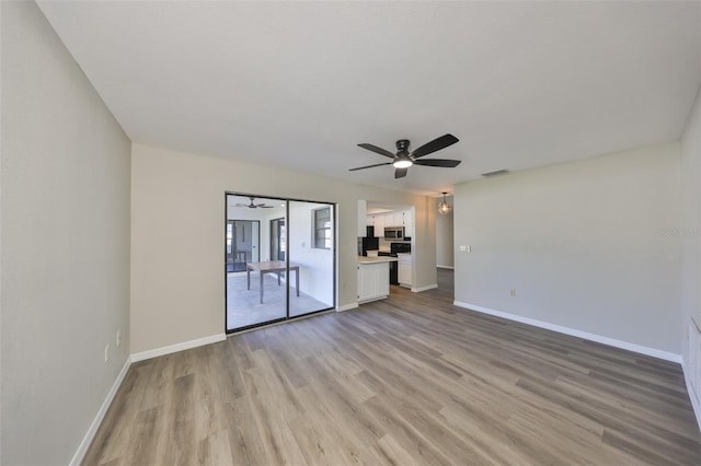 unfurnished room featuring light wood-style flooring, visible vents, baseboards, and a ceiling fan