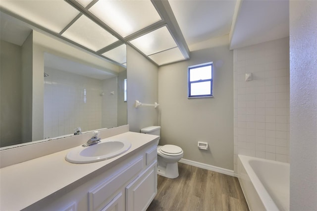 full bath with vanity, wood finished floors, toilet, and baseboards