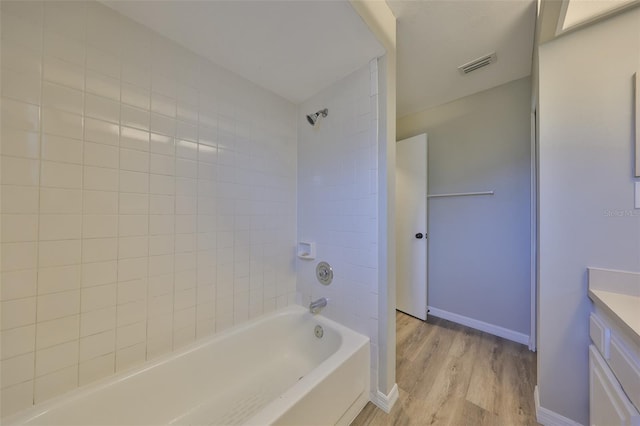 full bathroom featuring bathtub / shower combination, visible vents, vanity, wood finished floors, and baseboards