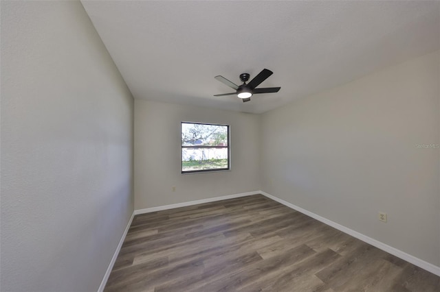 unfurnished room featuring dark wood-type flooring, baseboards, and a ceiling fan