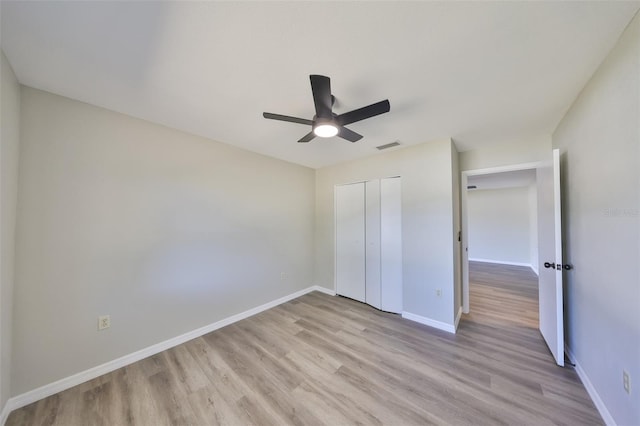 unfurnished bedroom with a closet, light wood-type flooring, and baseboards