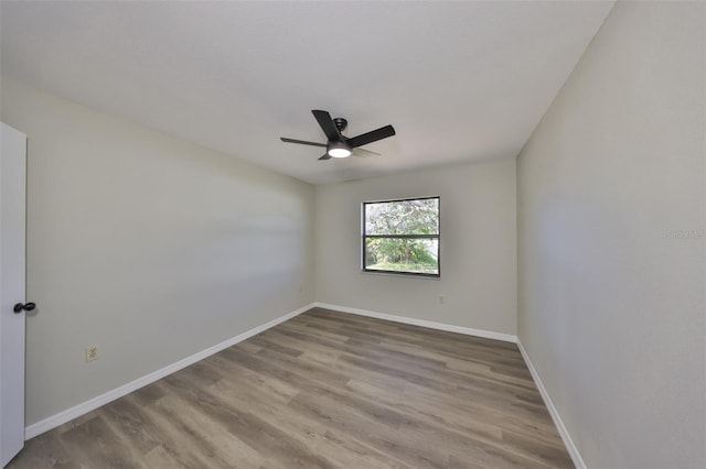 empty room with a ceiling fan, baseboards, and wood finished floors