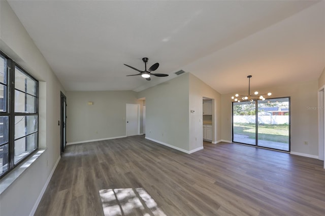 unfurnished living room with ceiling fan with notable chandelier, visible vents, baseboards, vaulted ceiling, and dark wood finished floors