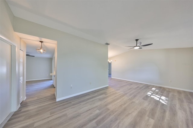 unfurnished room with ceiling fan, vaulted ceiling, light wood-type flooring, and baseboards