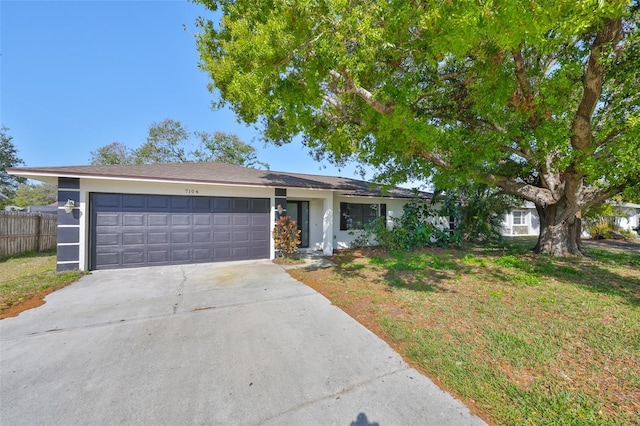 single story home with stucco siding, a front yard, fence, a garage, and driveway