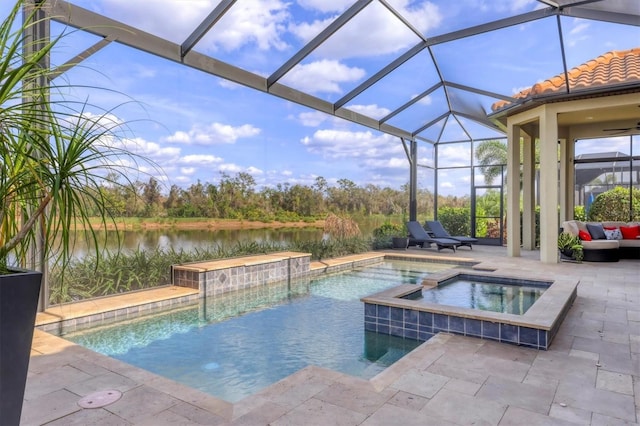 view of pool featuring a patio area, a pool with connected hot tub, and a water view