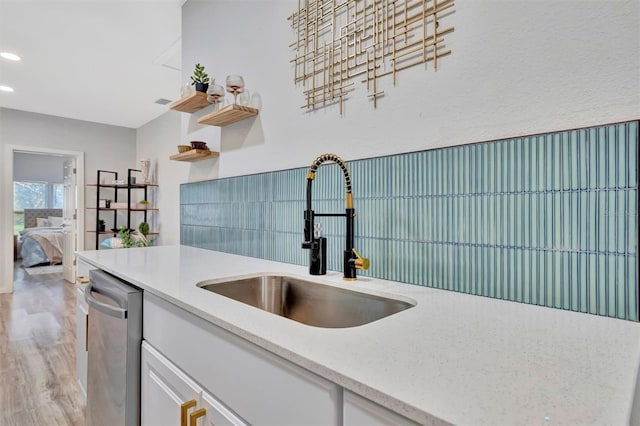 kitchen with dishwasher, light wood-style floors, white cabinetry, a sink, and recessed lighting