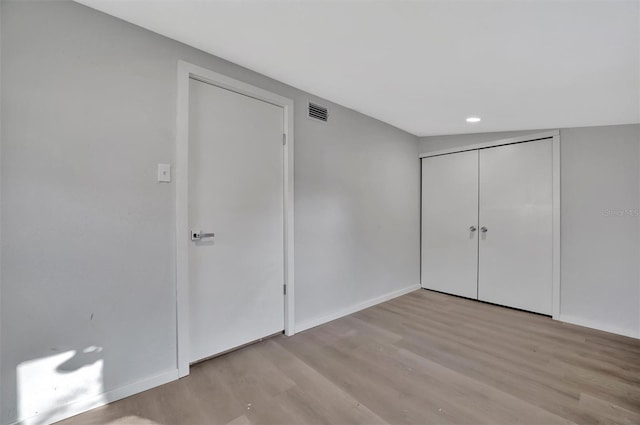 unfurnished bedroom with light wood finished floors, a closet, visible vents, and baseboards