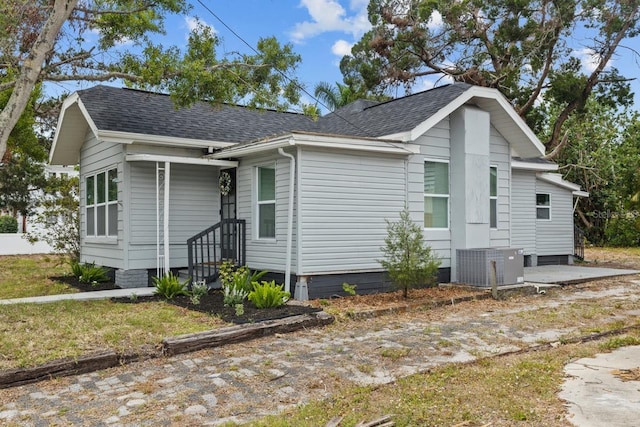 view of front of house with cooling unit and a shingled roof