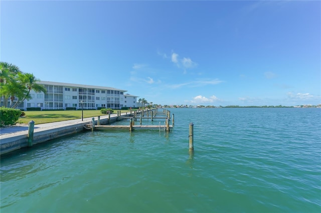 view of dock with a water view and a lawn