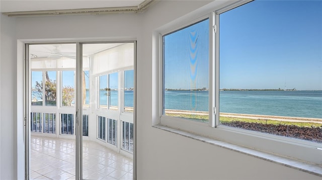 entryway with tile patterned flooring, a water view, and a healthy amount of sunlight