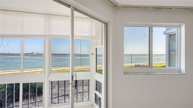 unfurnished sunroom featuring a water view