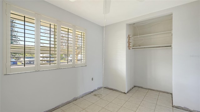 unfurnished bedroom featuring light tile patterned floors, baseboards, and a closet