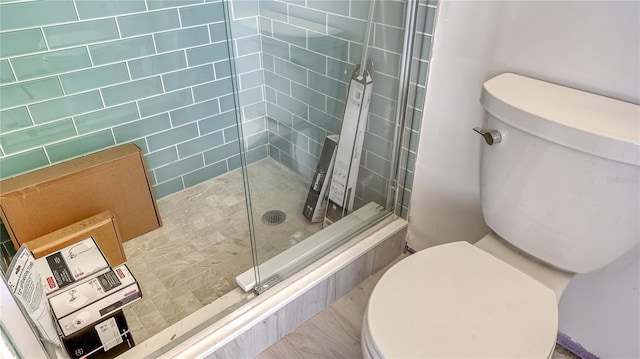 bathroom with toilet and tiled shower
