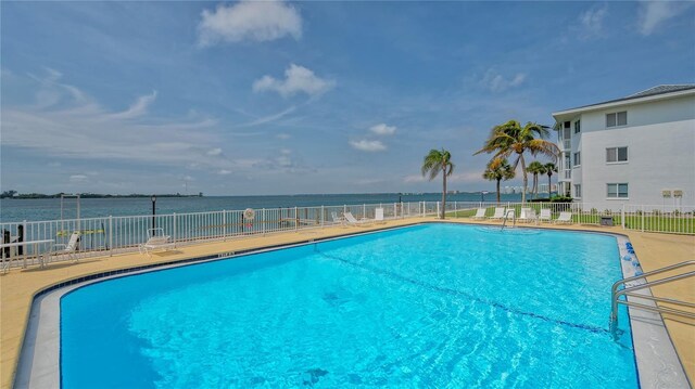 community pool featuring fence and a water view