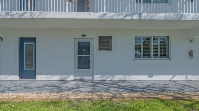 property entrance featuring a patio and stucco siding