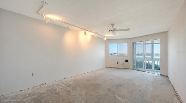 unfurnished room featuring a ceiling fan and unfinished concrete floors