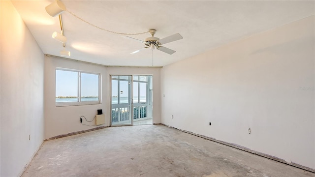 unfurnished room featuring a ceiling fan and unfinished concrete flooring