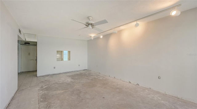 empty room with rail lighting, ceiling fan, and unfinished concrete flooring