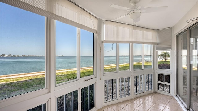 unfurnished sunroom with a water view and ceiling fan