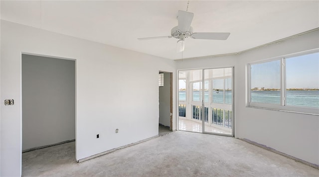 empty room with ceiling fan, concrete flooring, and a wealth of natural light