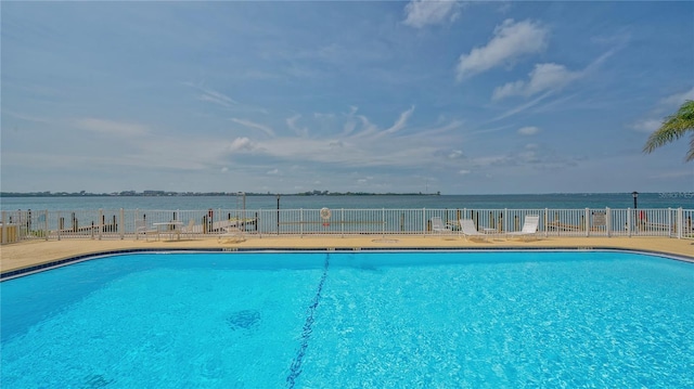 community pool featuring fence and a water view