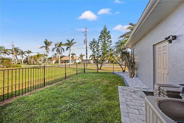 view of yard featuring central AC and fence