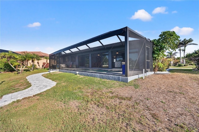 back of property featuring glass enclosure, an outdoor pool, and a yard