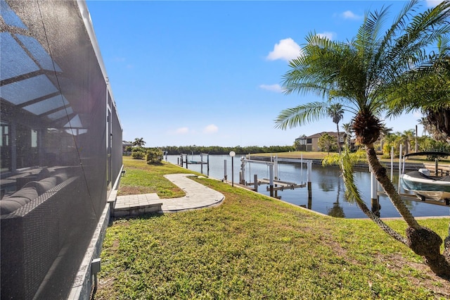 exterior space with a water view, boat lift, a lanai, and a dock