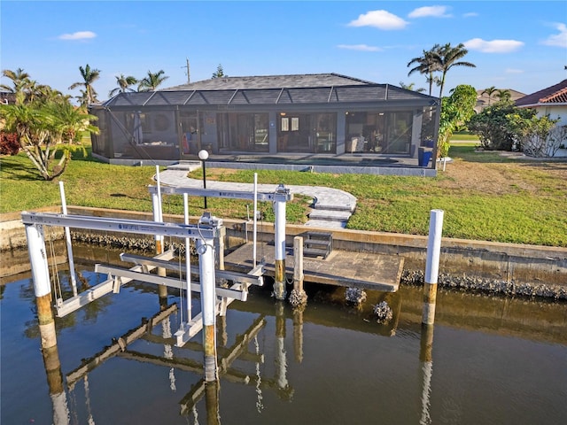 dock area featuring a yard, glass enclosure, a water view, and boat lift