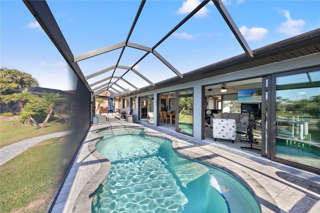 outdoor pool featuring a lanai, a water view, a patio, and ceiling fan