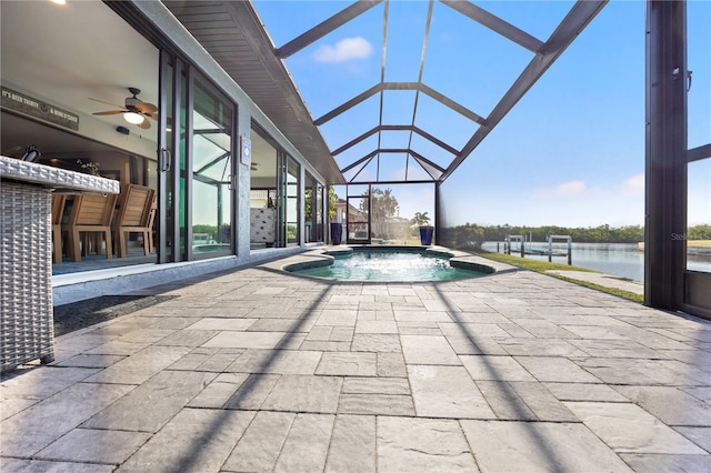 view of swimming pool featuring a patio area, a water view, a lanai, and a ceiling fan