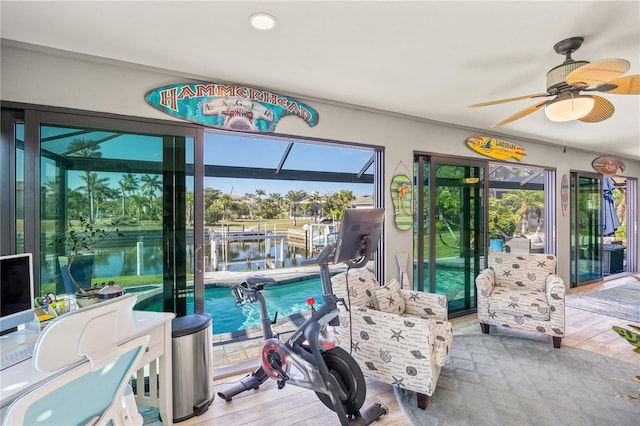 interior space with ceiling fan, a water view, and a healthy amount of sunlight