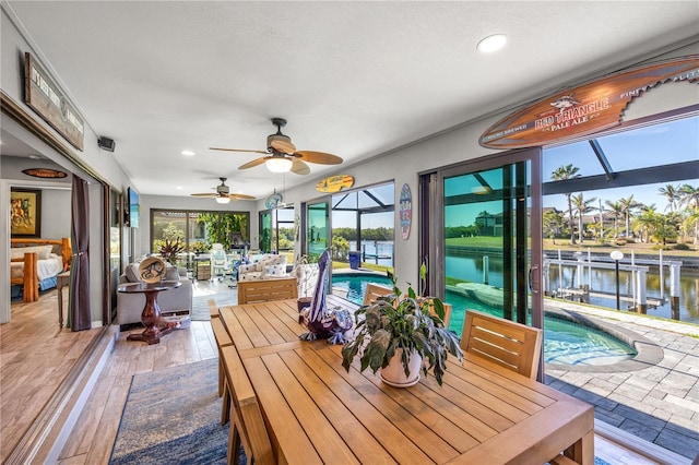 sunroom featuring a swimming pool and a water view