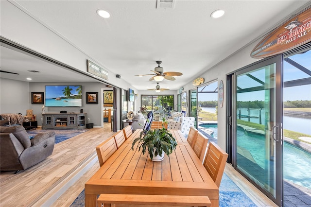 sunroom / solarium with a water view and visible vents