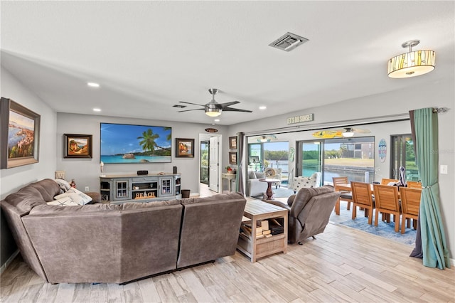 living room with light wood-type flooring, ceiling fan, visible vents, and recessed lighting