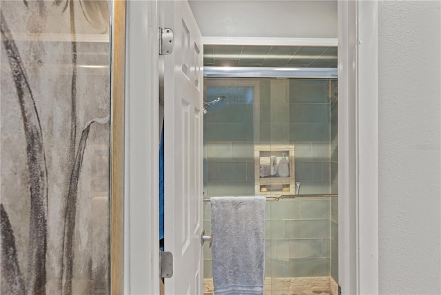 full bathroom featuring a stall shower and a textured wall