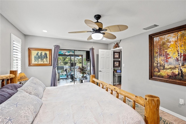 bedroom with wood finished floors, a ceiling fan, baseboards, visible vents, and access to exterior