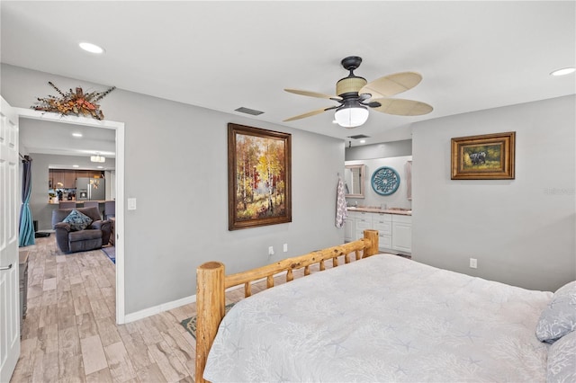 bedroom featuring baseboards, recessed lighting, light wood-style flooring, and stainless steel fridge with ice dispenser