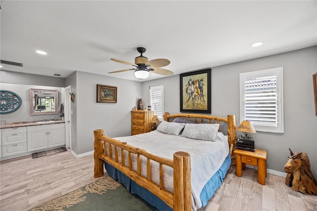 bedroom with baseboards, visible vents, light wood-style floors, a sink, and recessed lighting