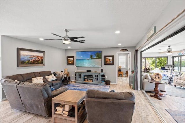 living area featuring light wood-style floors, recessed lighting, baseboards, and a ceiling fan