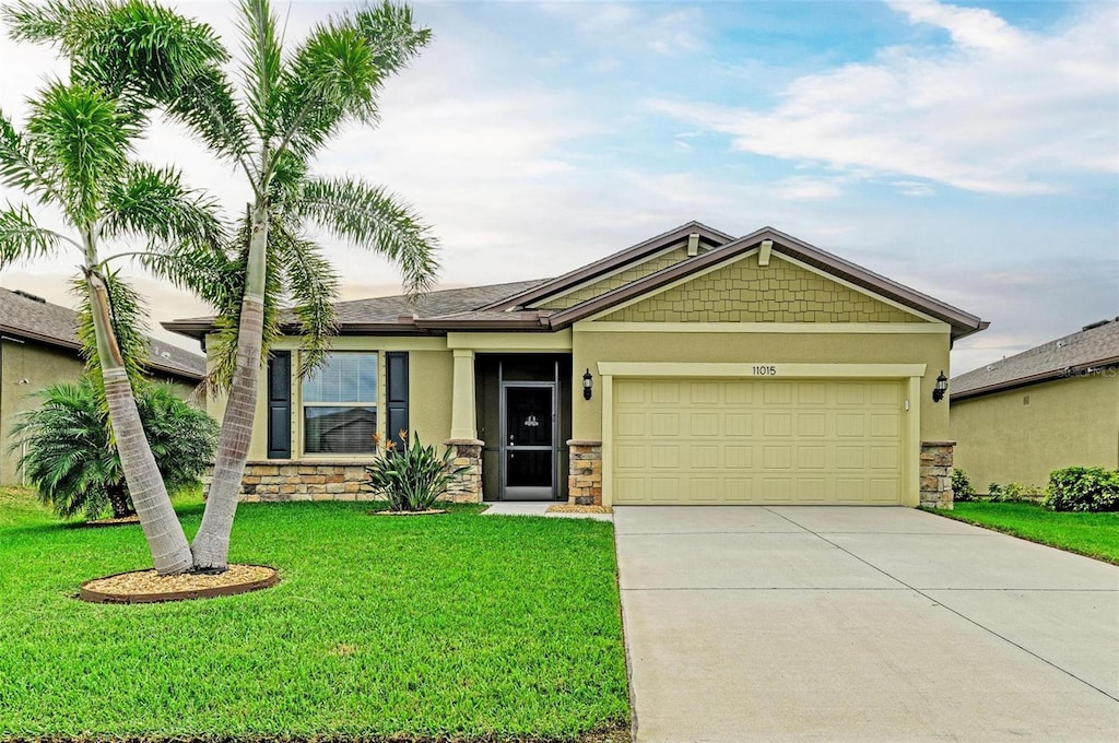 11015 48th St E, Parrish, FL 34219 - view of front of house with a garage, stone siding, and stucco siding