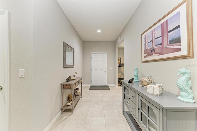 hallway featuring light tile patterned floors and baseboards