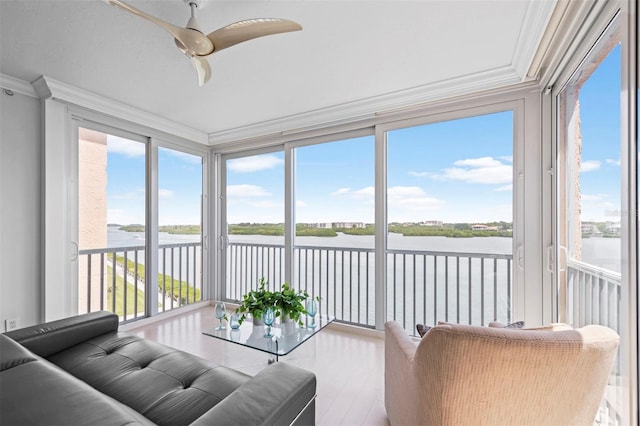 sunroom featuring a water view and a ceiling fan