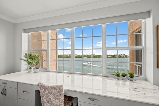 kitchen with light stone counters, gray cabinets, a water view, and built in study area